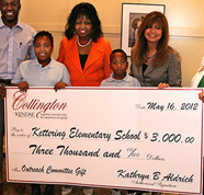 A picture of students and staff of Kettering Elementary School holding a check for 3000 dollars donated by Collington residents.