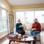 two resident women chatting in sunroom