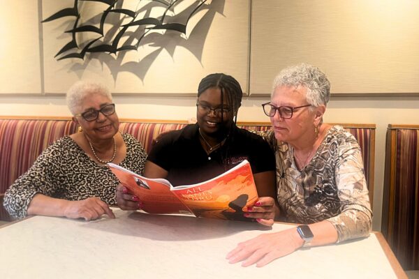 Jamisha with residents reading her book.